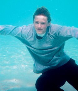 Swimming underwater in baggy sweatshirt